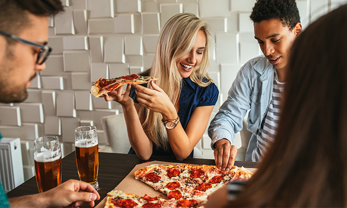 People enjoying a large pizza