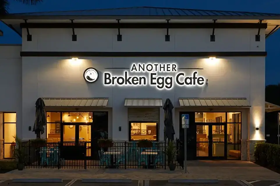 Another Broken Egg Cafe franchise front at night with lighted lettering